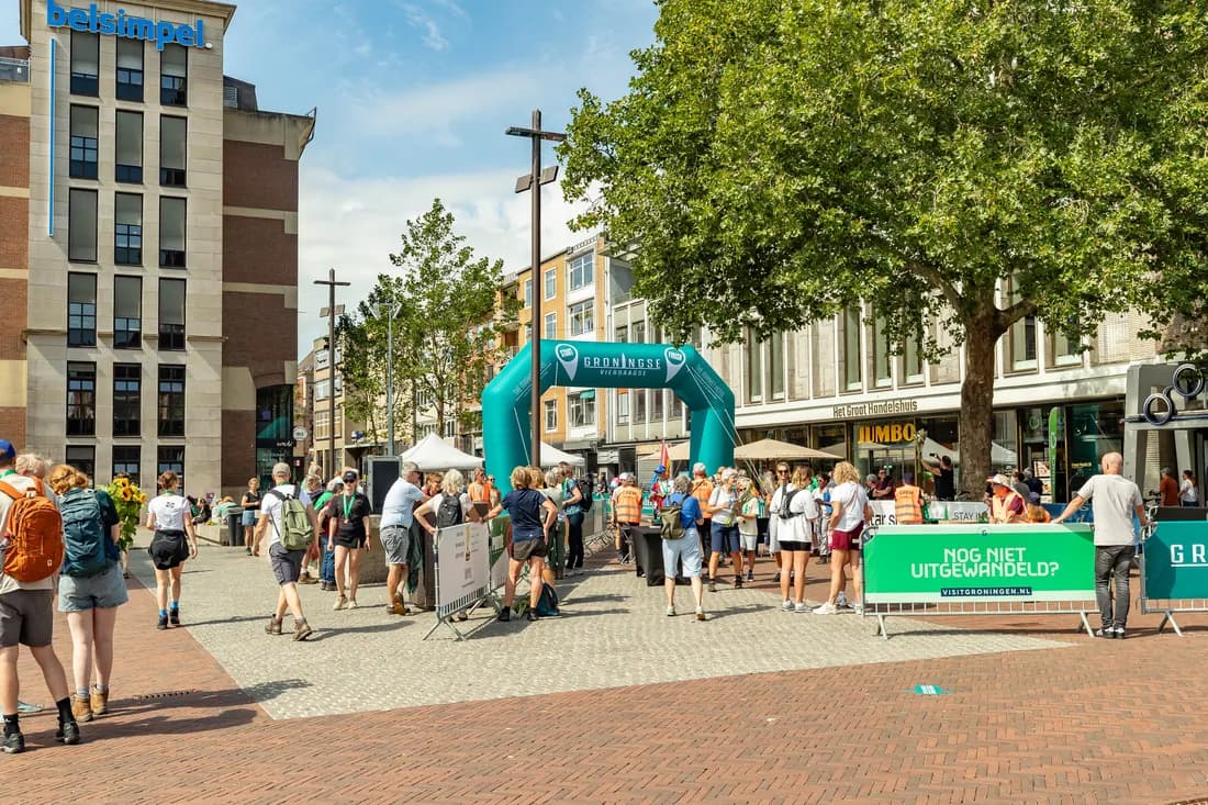 Wandelaars bij de boog van de Groningse 4daagse op de Grote Markt